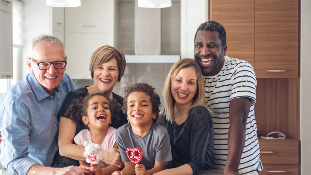 A smiling multigenerational expat family in their home, representing the peace of mind that comes with understanding the work permit vs residence permit requirements in Ghana.