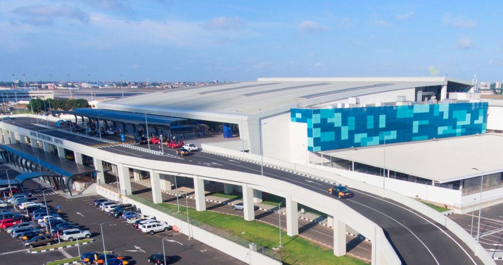 Elevated view of Terminal 3 at Kotoka International Airport (KIA) in Accra, Ghana, showing the modern drop-off flyover, passenger terminal, and parking lot, serving as a primary West African destination hub for corporate travel.